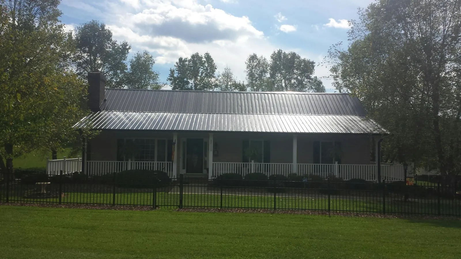 Gray metal roof on a brick ranch with a full width front porch — Gutter Guard Installation work by our crew in Drayden
