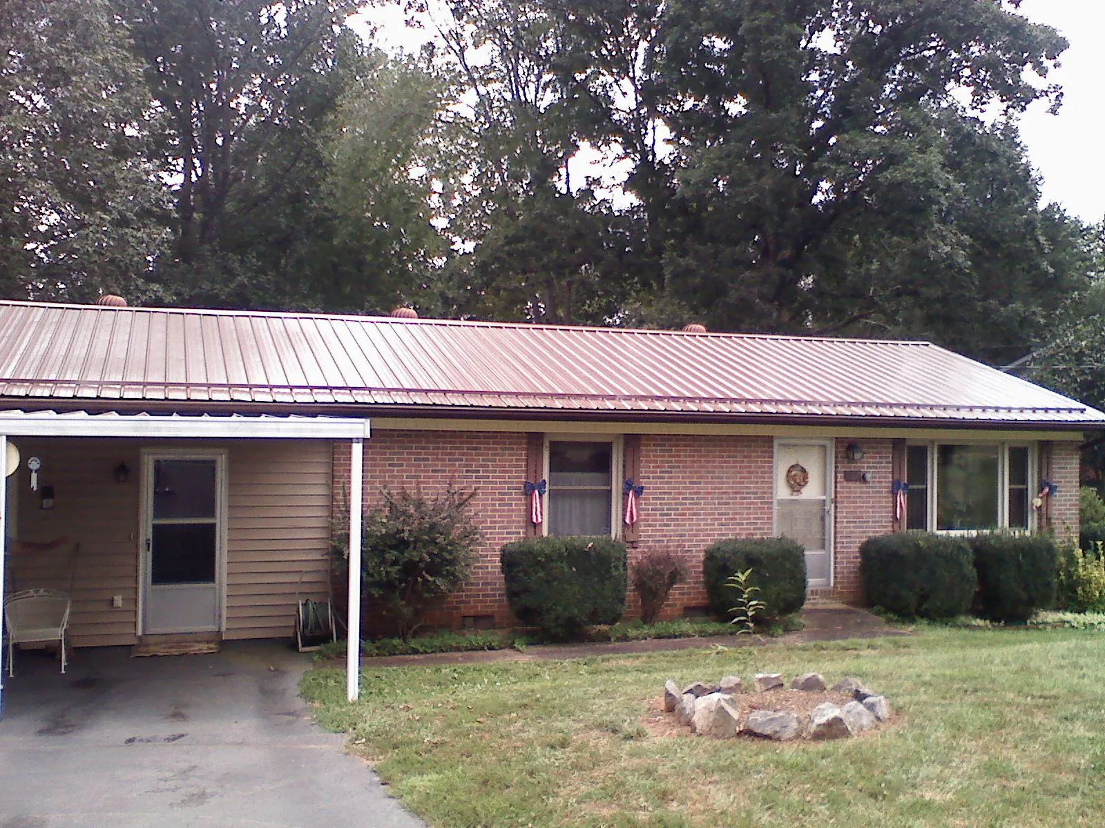 Bronze metal roof and carport on a brick ranch home — Roof Repair work by our crew in Drayden